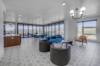A spacious living room with a large window overlooking the mountains.